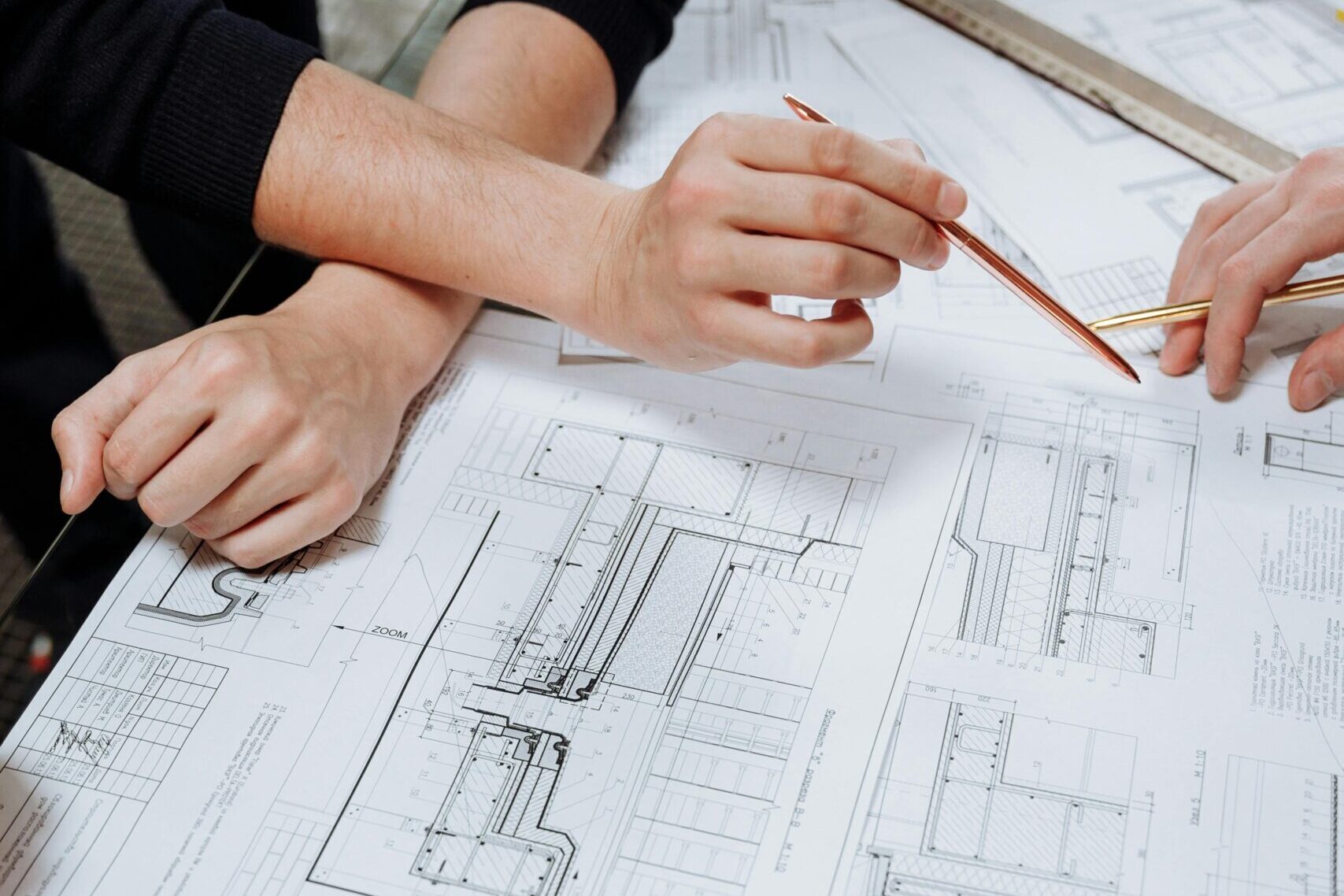 Architects discussing detailed blueprints and schematics at a table.